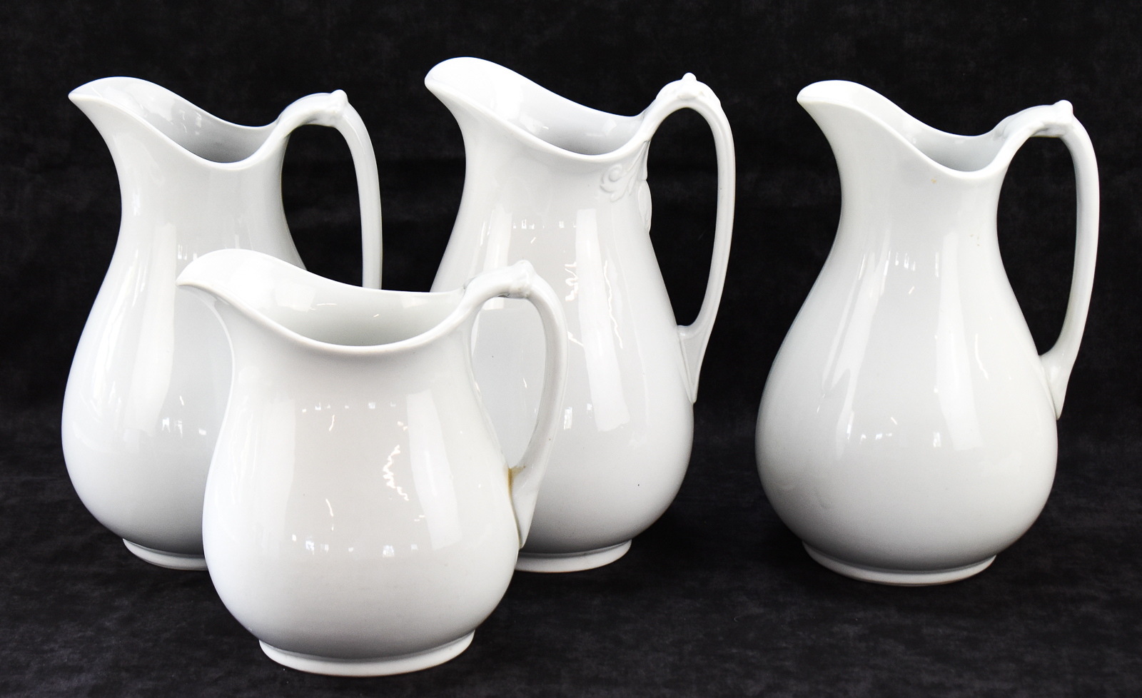 FOUR ENGLISH WHITE IRONSTONE PITCHERS: J & G MEAKIN, WEDGWOOD