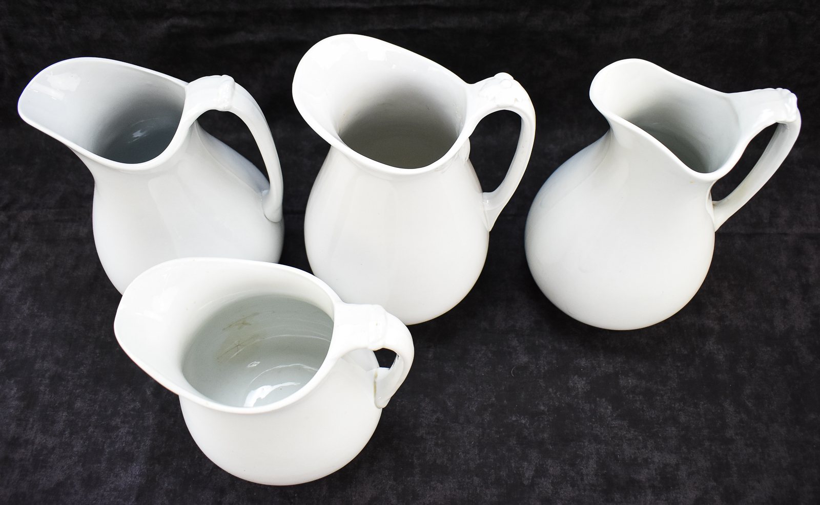 FOUR ENGLISH WHITE IRONSTONE PITCHERS: J & G MEAKIN, WEDGWOOD