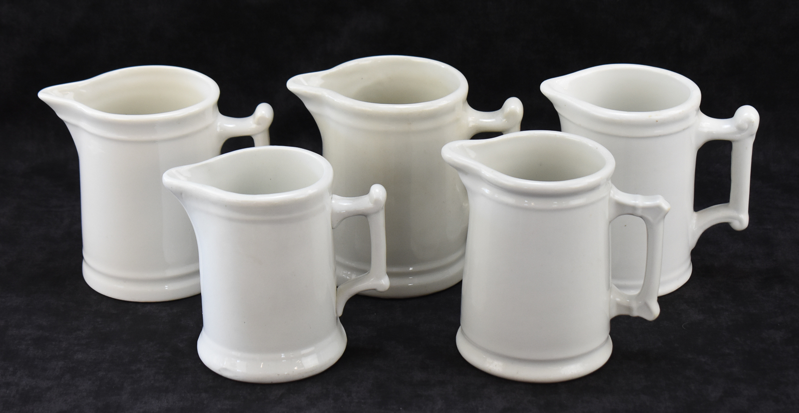 FIVE WHITE IRONSTONE MILK PITCHERS: WALKER CHINA, WEST END POTTERY, AND MORE