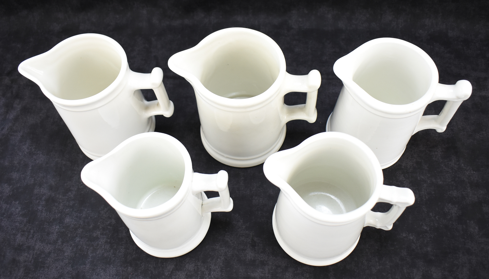 FIVE WHITE IRONSTONE MILK PITCHERS: WALKER CHINA, WEST END POTTERY, AND MORE