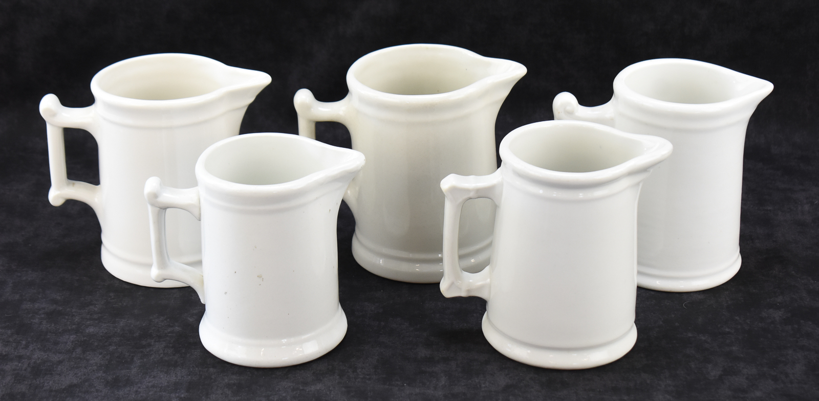 FIVE WHITE IRONSTONE MILK PITCHERS: WALKER CHINA, WEST END POTTERY, AND MORE