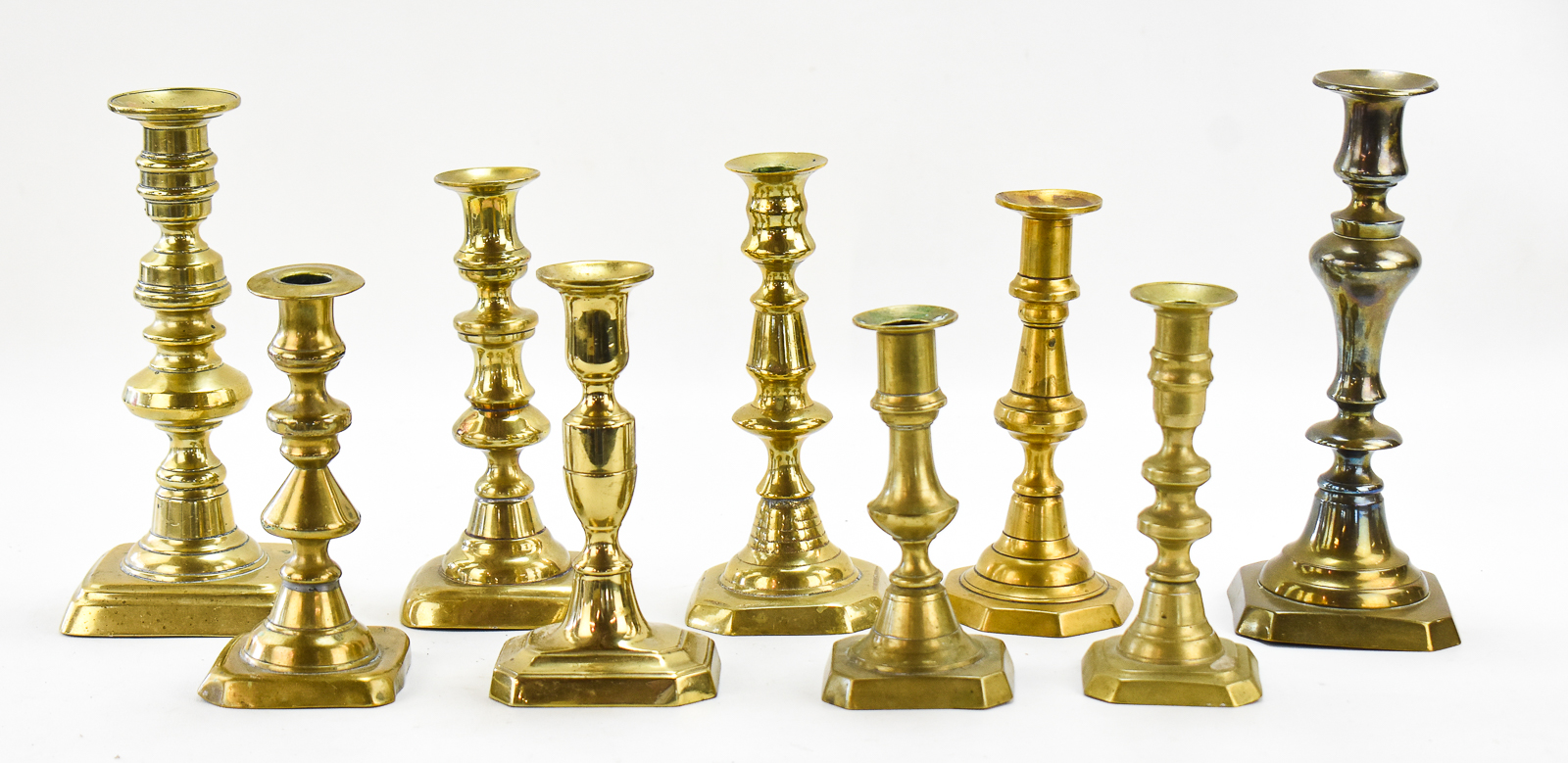NINE ENGLISH-STYLE BRASS CANDLESTICKS