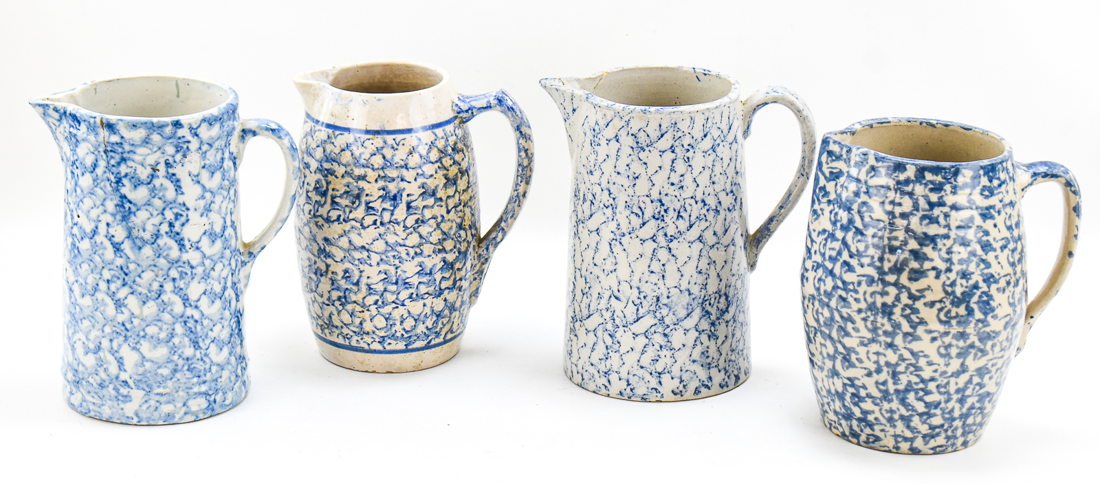 FOUR BLUE-AND-WHITE SPONGEWARE PITCHERS