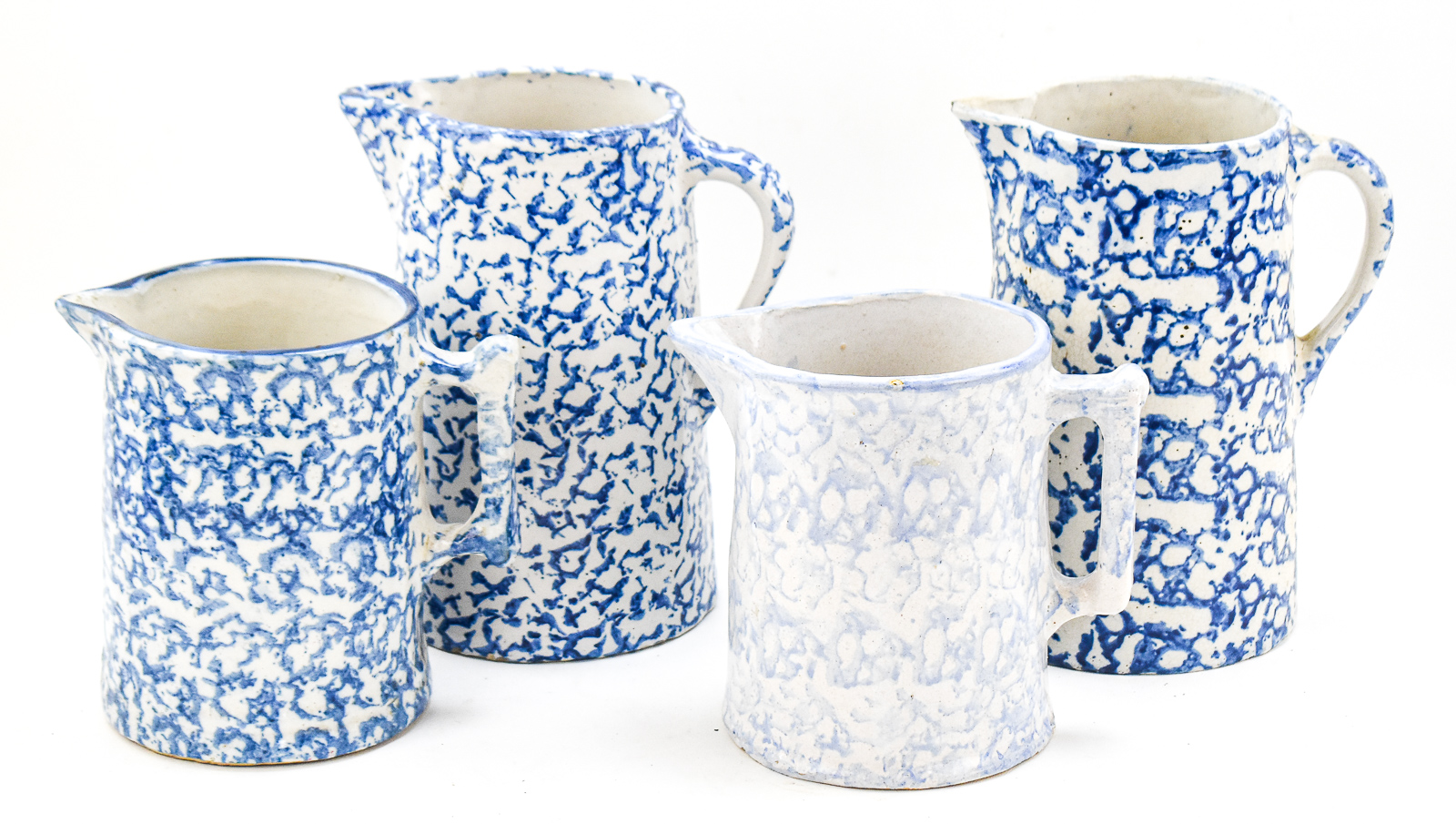 FOUR BLUE-AND-WHITE SPONGEWARE PITCHERS