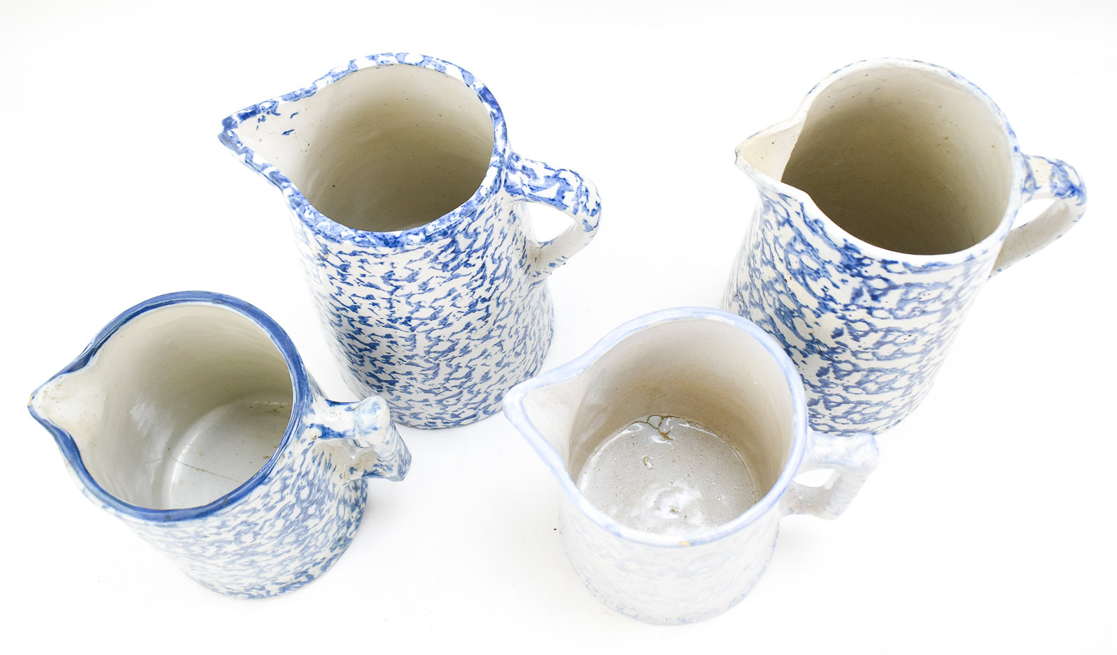 FOUR BLUE-AND-WHITE SPONGEWARE PITCHERS