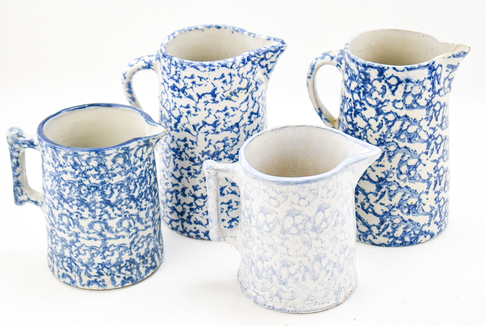 FOUR BLUE-AND-WHITE SPONGEWARE PITCHERS