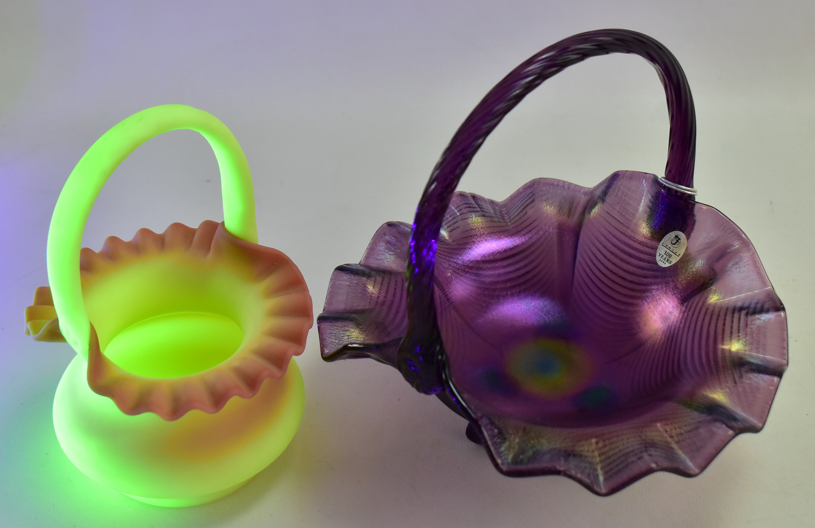 PAIR OF FENTON ART GLASS BASKETS: AMETHYST CARNIVAL GLASS AND BURMESE GLASS