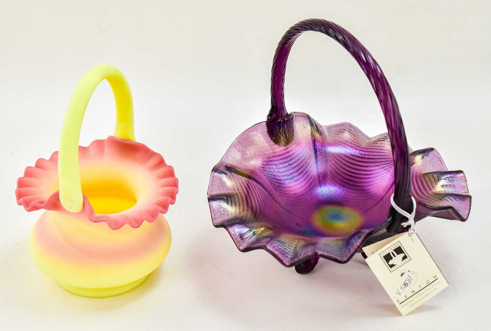 PAIR OF FENTON ART GLASS BASKETS: AMETHYST CARNIVAL GLASS AND BURMESE GLASS