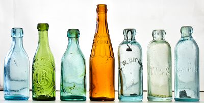 ASSORTED COLOR GLASS BOTTLES: WEST BROMWICH, C.W. BICHAM, C.W. EPLER, AND MORE. This lot has 