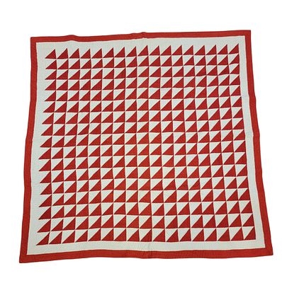 PIECED QUILT. American, late 19th century, cotton. Triangles, in red and printed white fabric 
