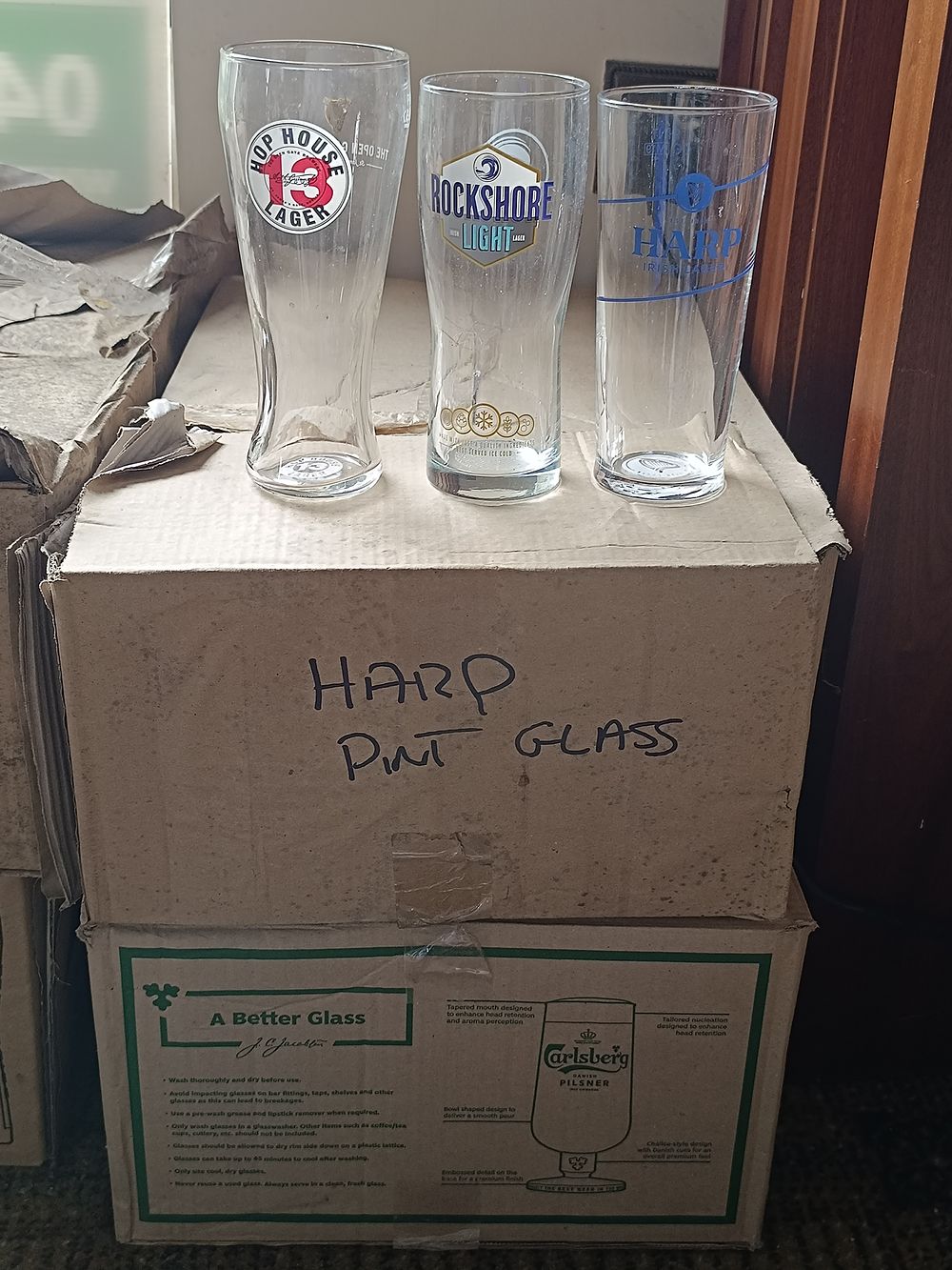 A 2 Boxes of Harp Irish Lager and Hop House, Rockshore Pint Glasses