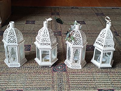 A Group of Four White-Painted Metal Moroccan Style Candle Lanterns