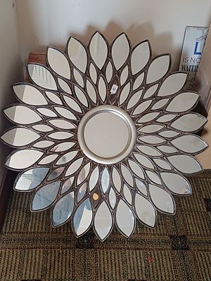 A Decorative Sunburst Wall Mirror with Petal-Form Mirrored Segments