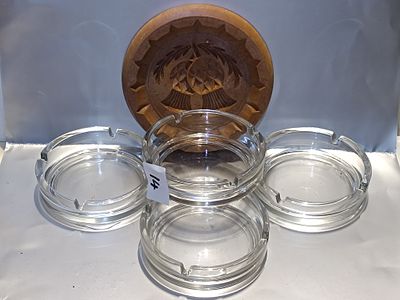 A Group of Four Clear Glass Ashtrays and a Carved Folk Art Wooden Plaque