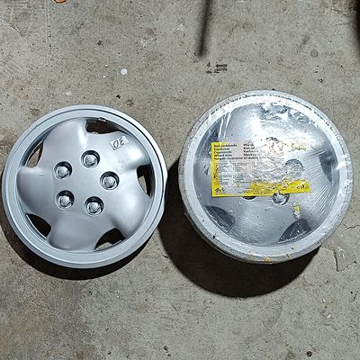 A Set of Four Mena 13 Inch Universal Wheel Trims