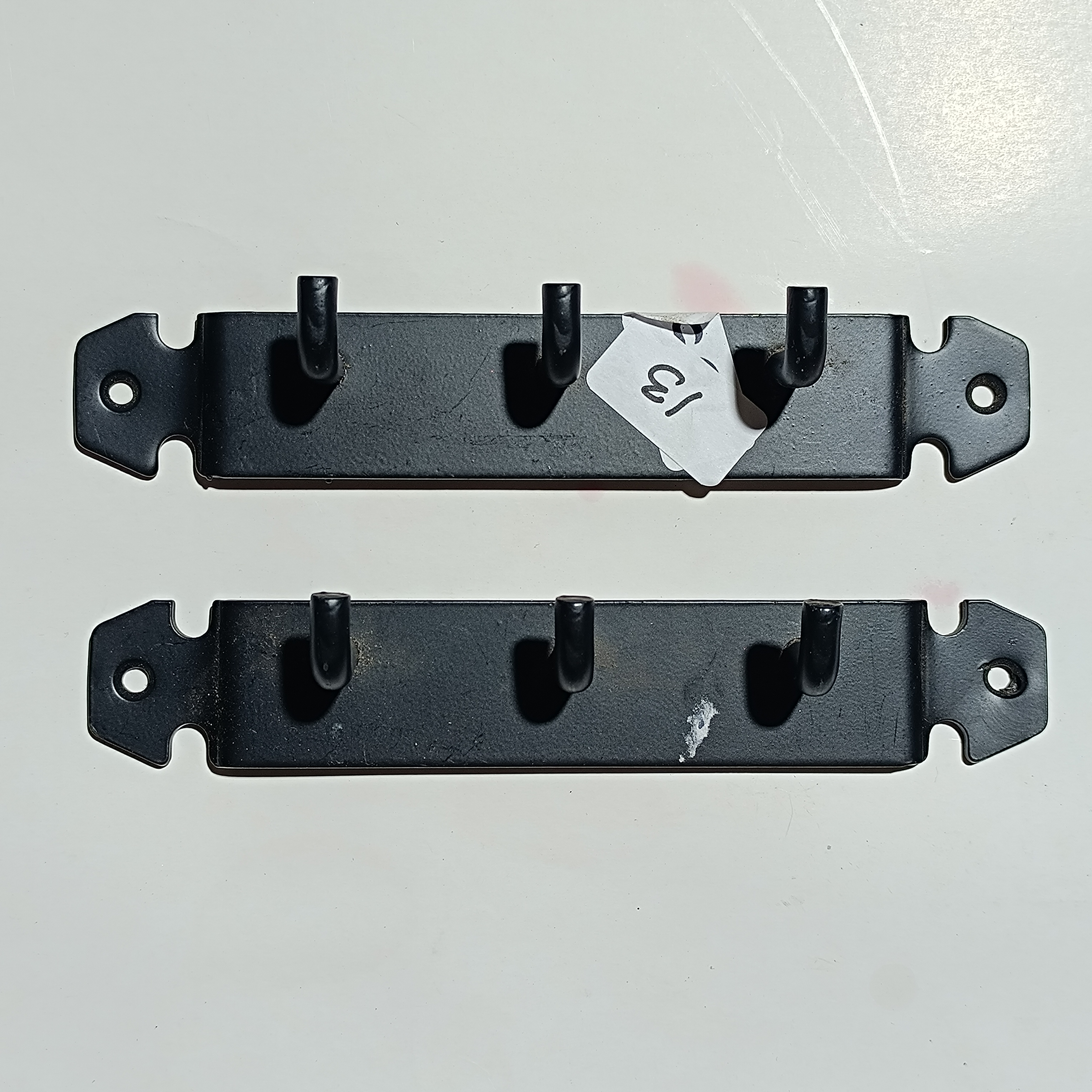 A Pair of Black Painted Metal Three-Hook Wall Racks