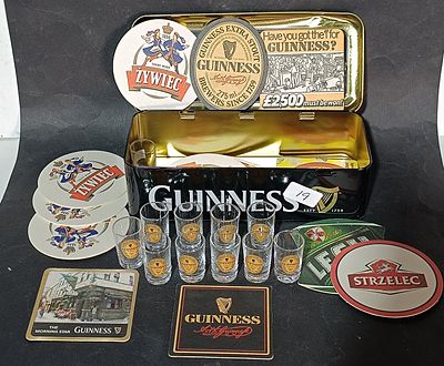 An Assortment of Guinness Collectibles Including Shot Glasses, Coasters and Storage Tin