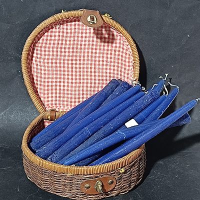 A Set of Approximately 14 Blue Taper Candles in Wicker Carrying Case