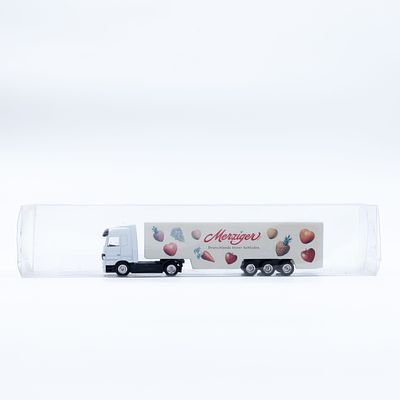 משאית מיניאטורית עם נגרר Merziger. דגם משאית עם נגרר, כולל מיתוג Merziger, מוצג בתוך מארז פלסטיק 
