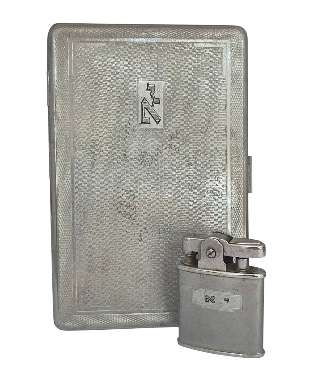 קופסת סיגריות ומצית ניתנו בהוקרה ל יונתן אטקס (1935 – 2024) שהיה טייס חיל האוויר וטייס אל על 