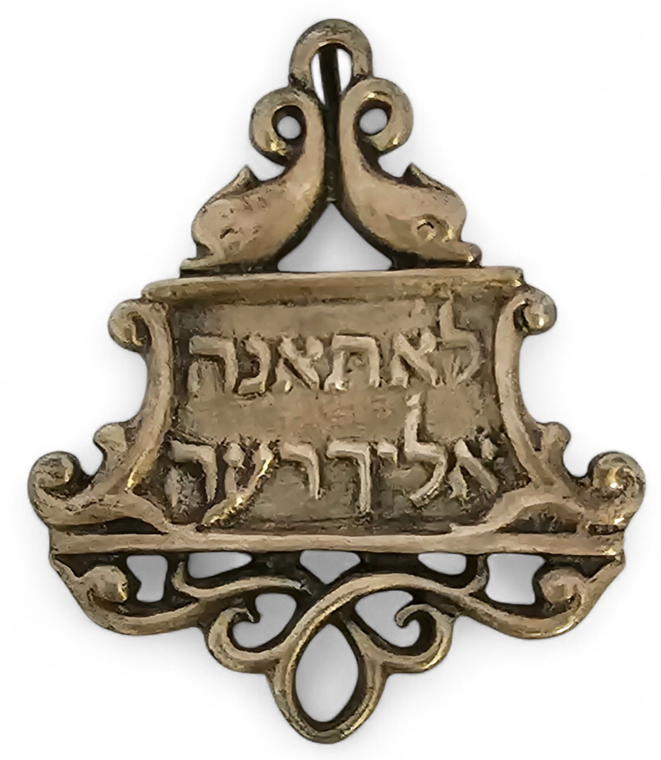 Plaque made of silver with the words, in Hebrew, "Lo Te'une elecha re'eh" (translated to: no 