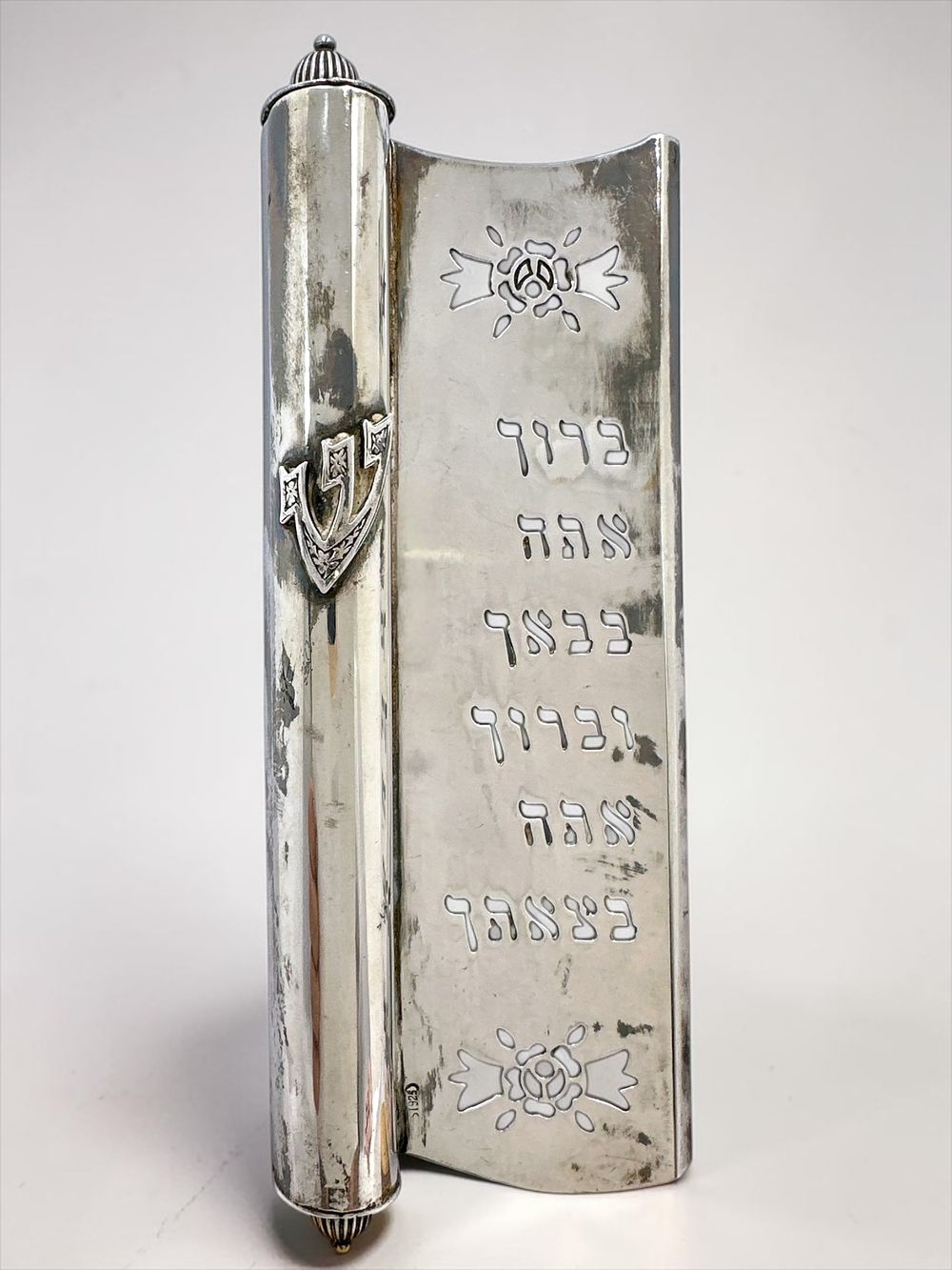 Sterling silver mezuzah, decorated with engraved work and inscribed "Blessed are you in your 