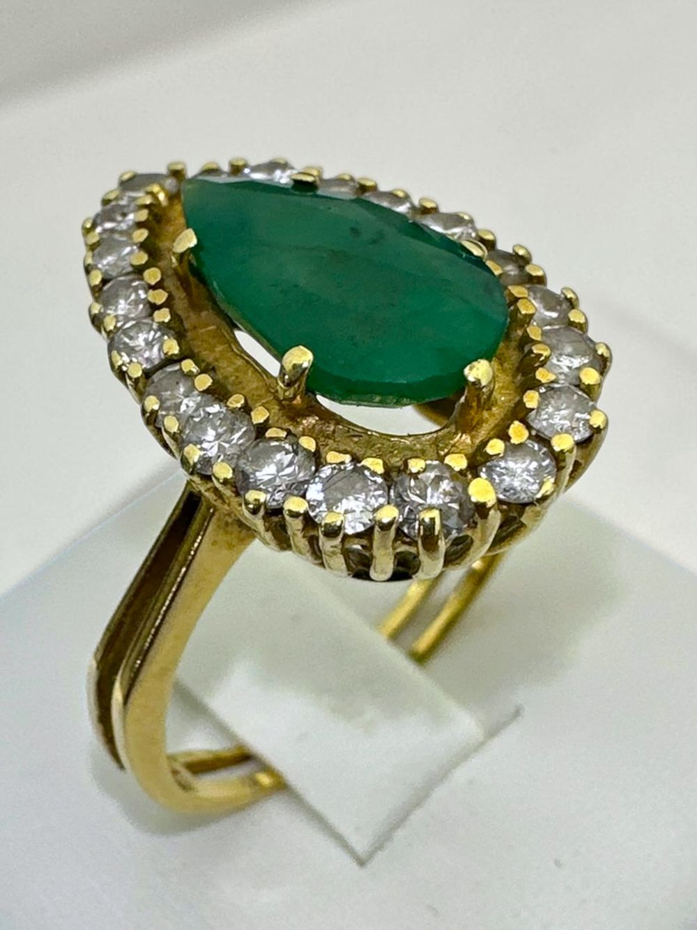 14k gold ring with pear cut emerald (2 carats) at center with halo of pave diamonds (66 