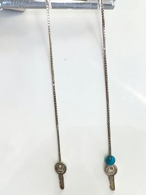 זוג עגילי כסף 925 איטלקים, עם קצה מפתח, ובאחד חרוז טורקיז. 
מידות 9.5 ס"מ 
