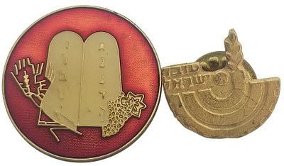 יודאיקה+ישראלינה.. 
תליון עגול בעל רקע אדום, עליו מופיע תבליט של לוחות הברית הנושאים את עשרת 