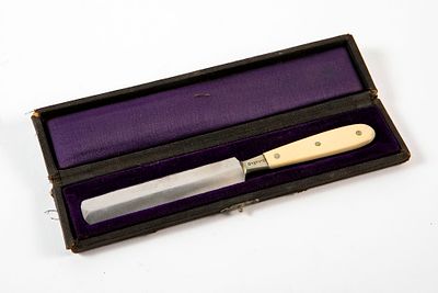 An American Jewish mohel knife, made of metal and an enameled handle, bearing Yiddish 