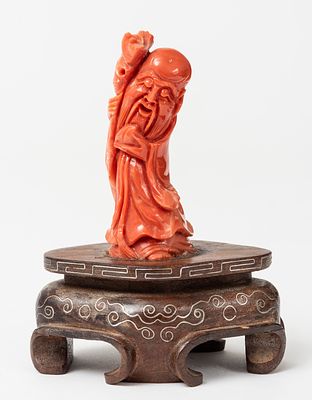 CHINESE SAGE. China, coral (?), wooden base, 20th century. 
H: 7 cm (without base), 129g