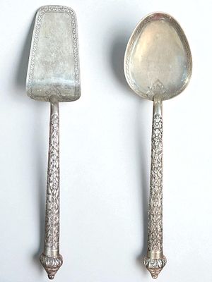 שתי כפות הגשה עתיקות ומעוטרות עשויות כסף 800. אורך: 27 ס״מ, 29 ס״מ. 
משקל כולל: 166 גרם.