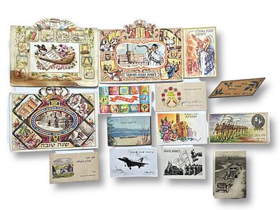 לוט 14 אגרות שנה טובה מוקדמות כולל אחת כתובה ביד על משטח עץ משנת תרצ"ו.