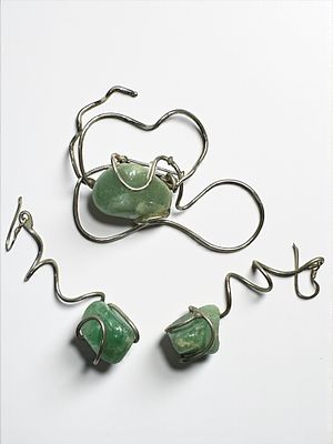 סיכה וזוג עגילים עשויים כסף סטרלינג משובצים אבנים ירוקות. חתומים. סיכה: 7x5 ס"מ. 
עגיל 6.5 ס״מ. 