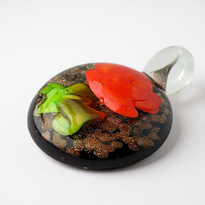 תליון זכוכית איטלקי ישן תוצרת מורנו, במרכזו עיטור שושנה. מידות: 4.4x3.3 ס"מ.