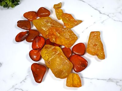 חרוזים וגושי ענבר טבעי בגוונים שונים.