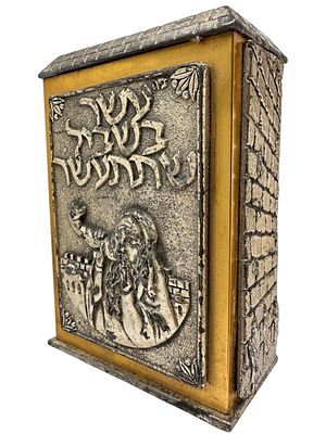 קופת צדקה ישראלית ישנה עשויה ציפוי כסף וזהב. תבליט יהודי תוקע בשופר והכותל. כיתוב ב"ה עשר בשביל 