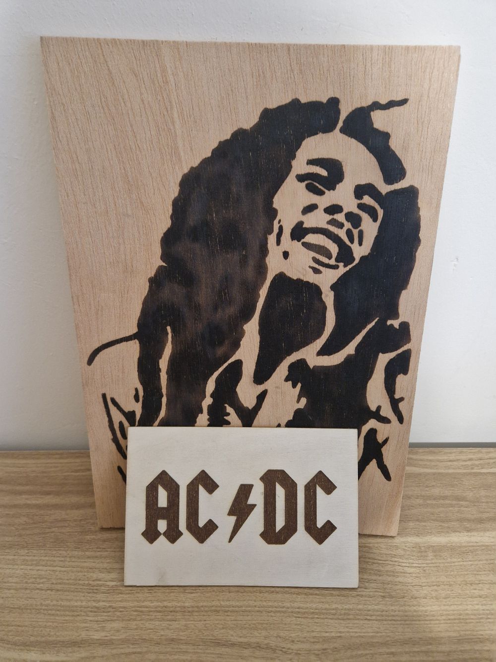 Lot 303: Bob Marley and Ac/DC burnt in wood art