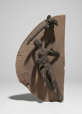 Scultura in bronzo applicata su legno. Materia: Bronzo a patina scura e supporto in legno 