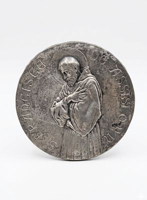 Placca circolare raffigurante San Francesco d'Assisi
Metallo sbalzato con finitura argentata. Pla 