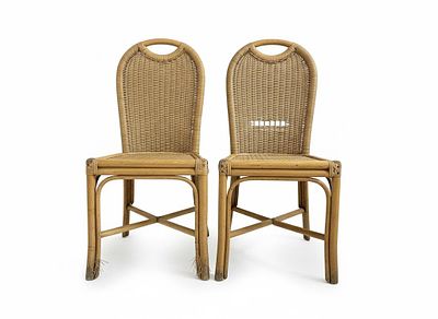 An elegant pair of chairs with an exotic and refined appeal, made of curved rattan and bamboo. 