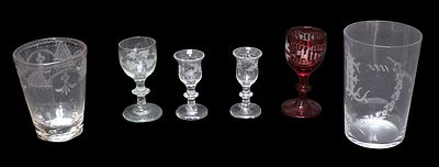 Two 18th century English dram glasses with bell-shaped bowls etched with fruiting vines, plain 