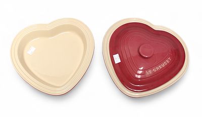 A pink, heart-shaped 2.4l Le Creuset dish and cover, together with a red Le Creuset 