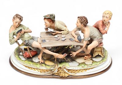 A Capodimonte porcelain figure of ‘The Cheats’, raised on naturalistic base with gilt detail 