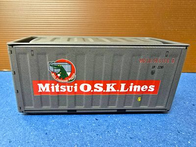 מכולה ימית מיניאטורית ממתכת - חברת לוגיסטיקה יפנית. המכולה ניפתחת באמצעות מכסה עליון ויכולה לשמש 