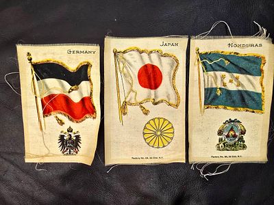 Items from 1910 - Embroidered fabric with country flags. An item made for tobacco boxes in 
