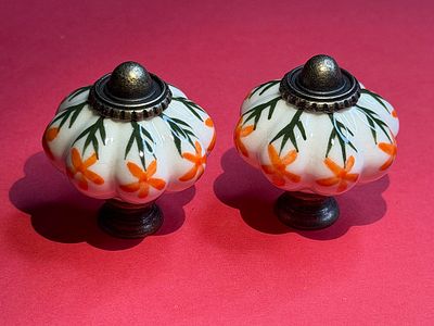 Porcelain knob handles combined with bronze-tone metal in a vintage-style "pumpkin" design. Diame 