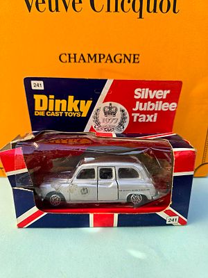 The image shows a collectible model of a London taxi (Austin FX4) from the Dinky Toys series 
