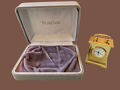 A miniature "Carriage Clock" table clock made by Bulova Japan, along with its original display box.