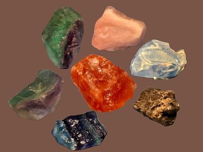 A collection of raw, unprocessed gemstones. The stones are natural, not polished or processed 